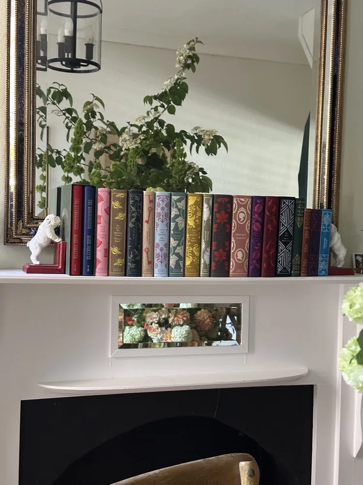 A shelf of colourful Penguin Classics above the fireplace