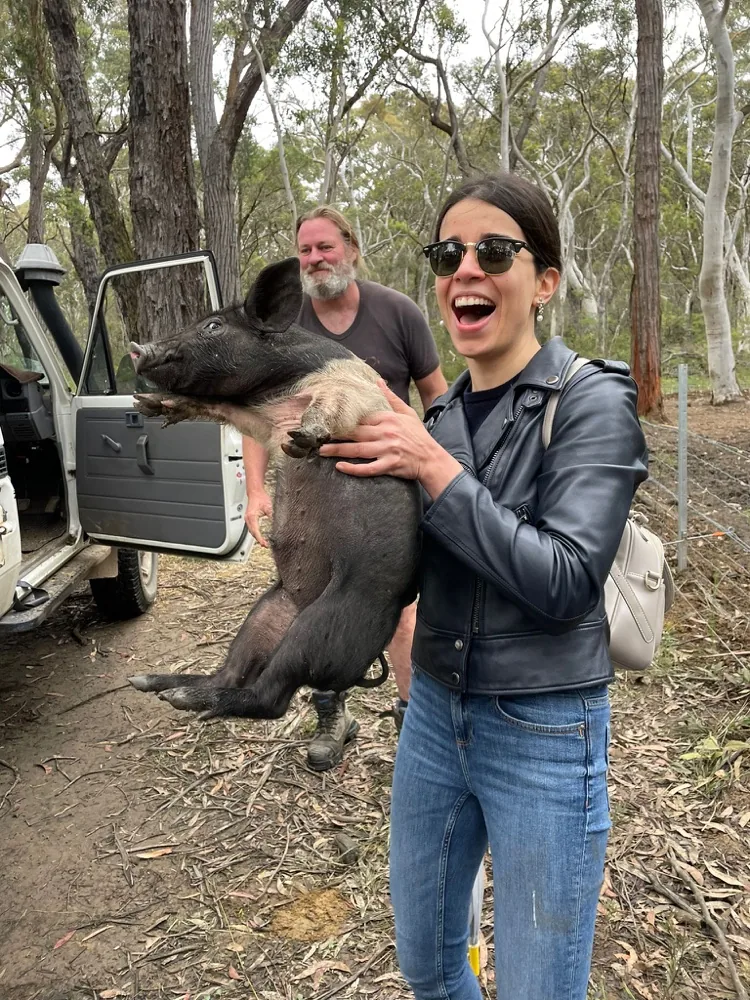 Me holding a pig in the bush and laughing